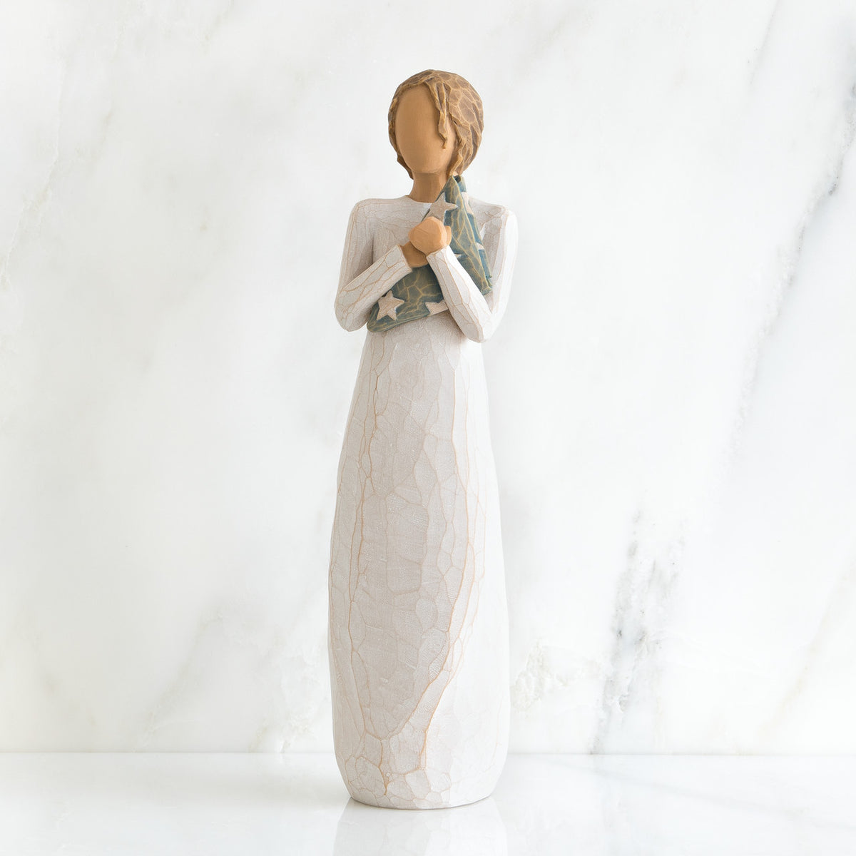 Faceless woman figurine standing facing forward wearing white dress holding star print napkin