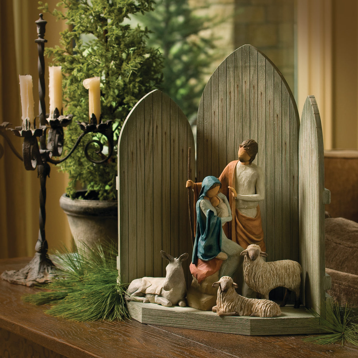 Side view of dark grey barn tri-fold on table with mary and joesph figurines in the center with two white sheep and donkey figurine under them