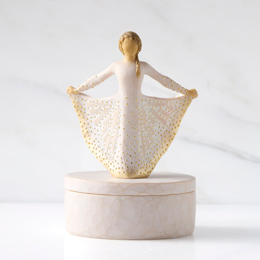 Front view: oval resin box, with 3-D figure in cream and gold carved dress atop lid