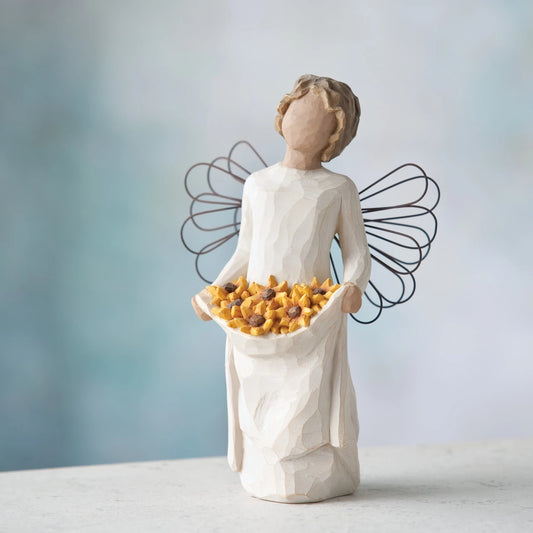Willow Tree Sunshine, 5.5”h hand-painted standing resin angel with darker skin and hair, cream dress and wire wings, holding up skirt full of Black-Eyed Susans, in front of blue grey painting