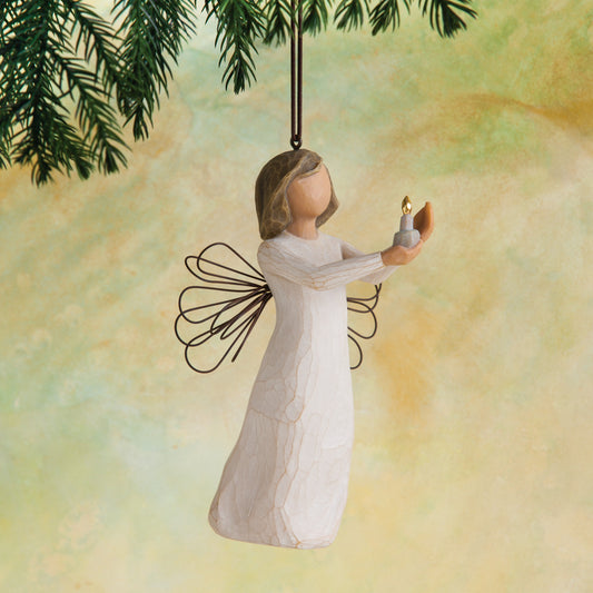 Willow Tree Angel of Hope Ornament, 4"h hand-painted resin figure in cream dress with wire wings, holding candle with gold-leaf flame in hands, brown elastic cord, hanging in front of dark yellow painting