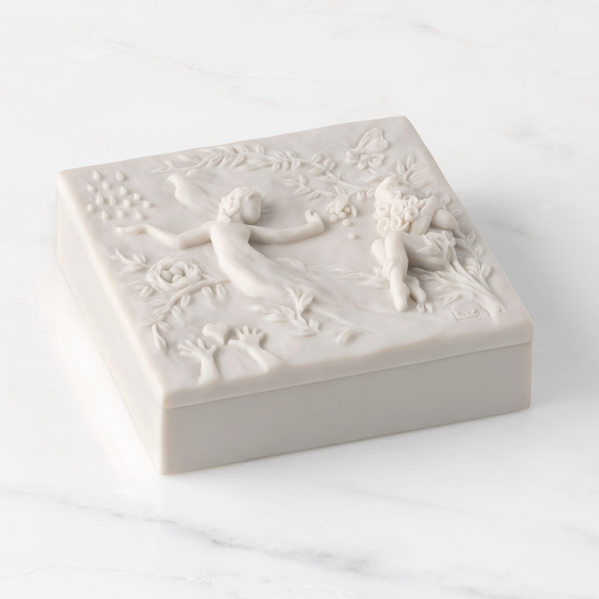 Closed white resin box; lid carved with figural and organic imagery, showing height of box sides