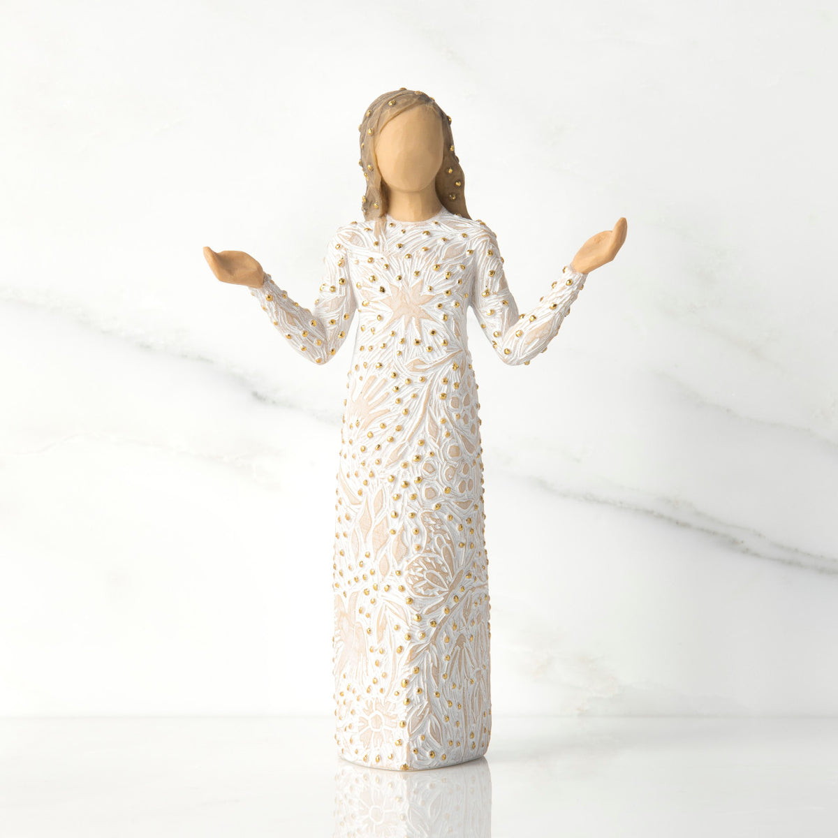 Front view of brunette girl figurine in white dress with gold dots holding her hands to the side